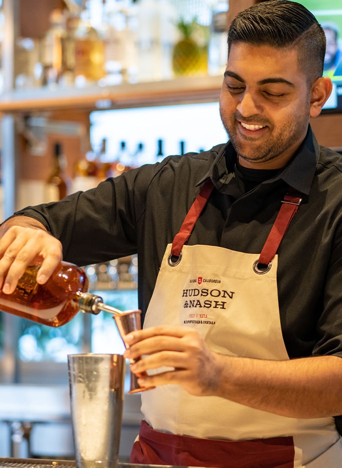 Bartender at Hudson & Nash preparing a signature cocktail