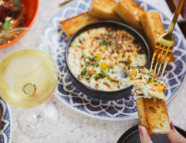 Our delicious Spinach & Artichoke dip served with sourdough crostini and a perfect pairing with a crisp white wine.